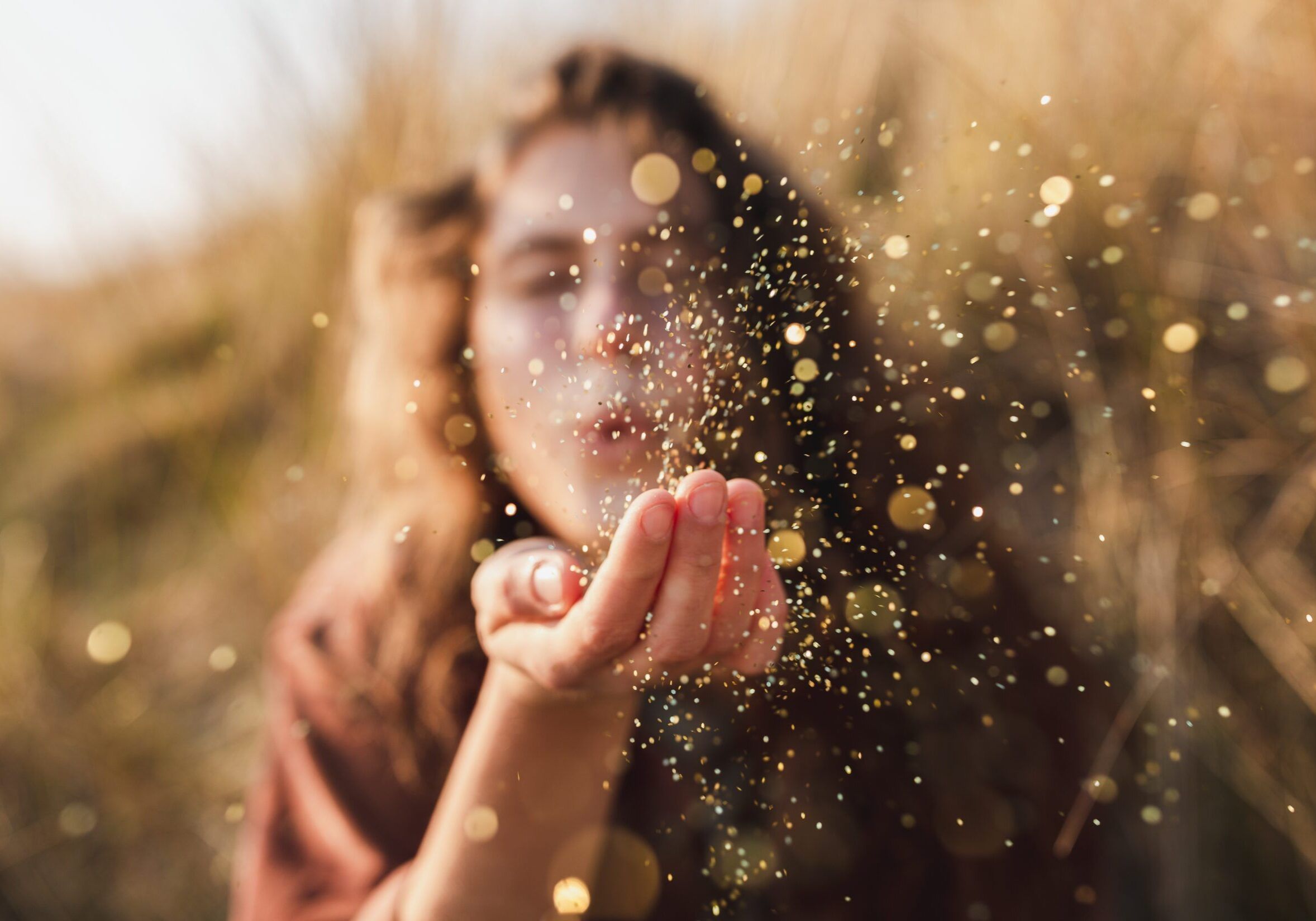 A beautiful shot of a model blowing glitter from her hand
